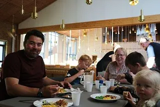 Familie med tre børn spiser pasta og kødsovs