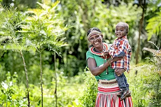Afrikansk kvinde med barn på armen