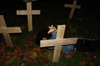 Mørk billede med hånd der rækker op fra kors