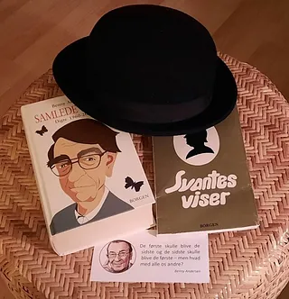 Benny Andersens samlede værker og en bowlerhat på lille bord