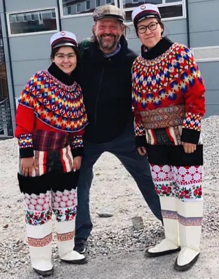 Foto af Lars Krogsholm der holder om to unge grønlandske piger.